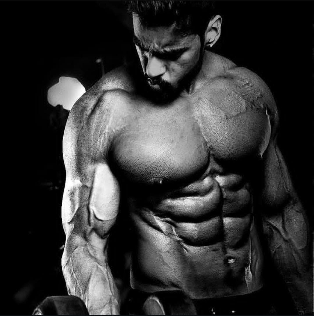 Abhinav Anand flexing in a dark studio setting